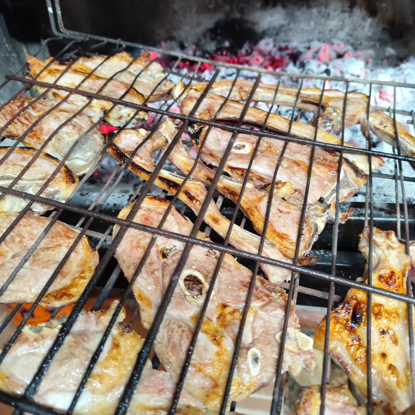 Carne a la brasa sobre parrilla de leña